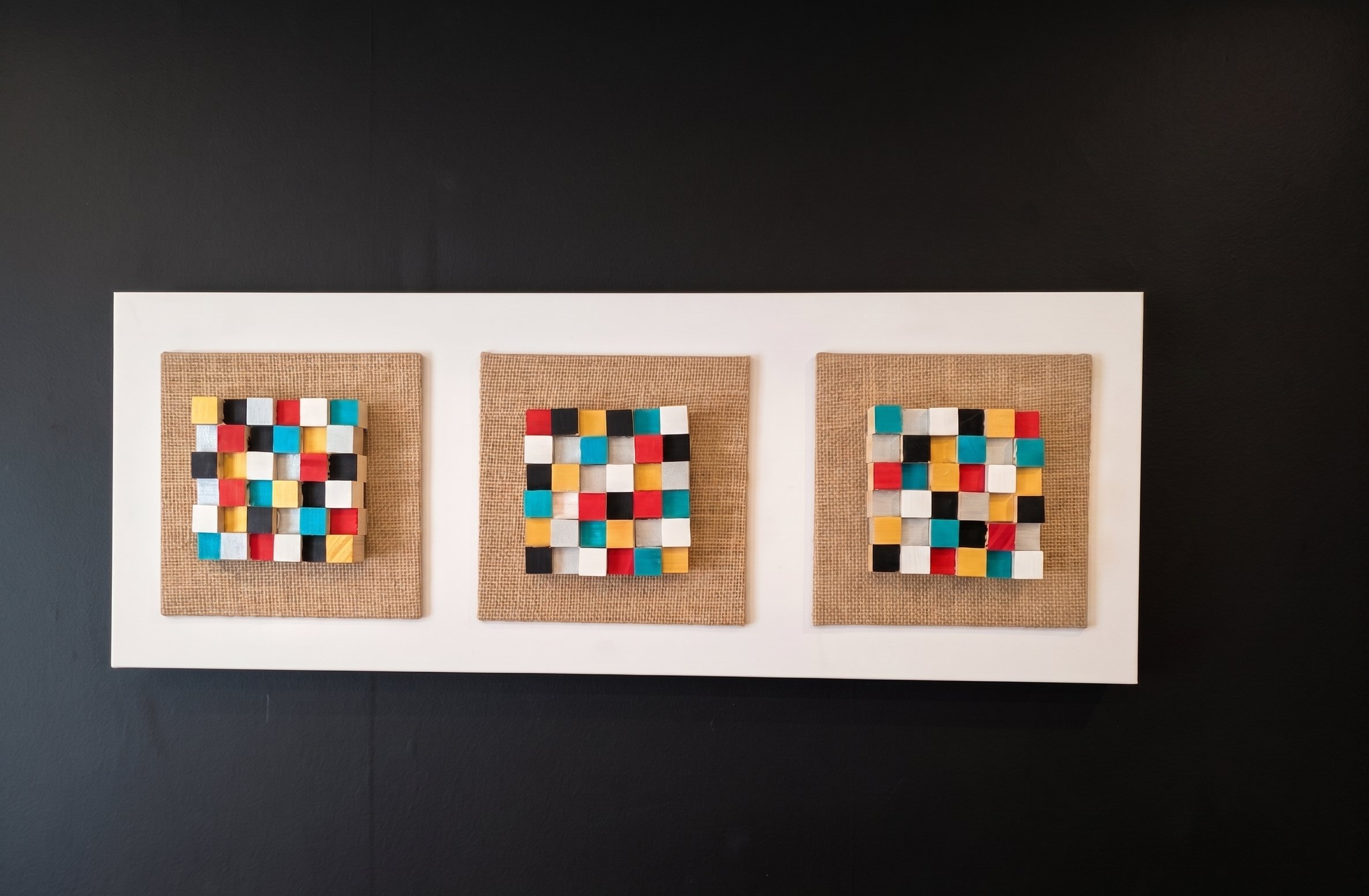 Coloured mosaic 3D triptych canvas on black wall