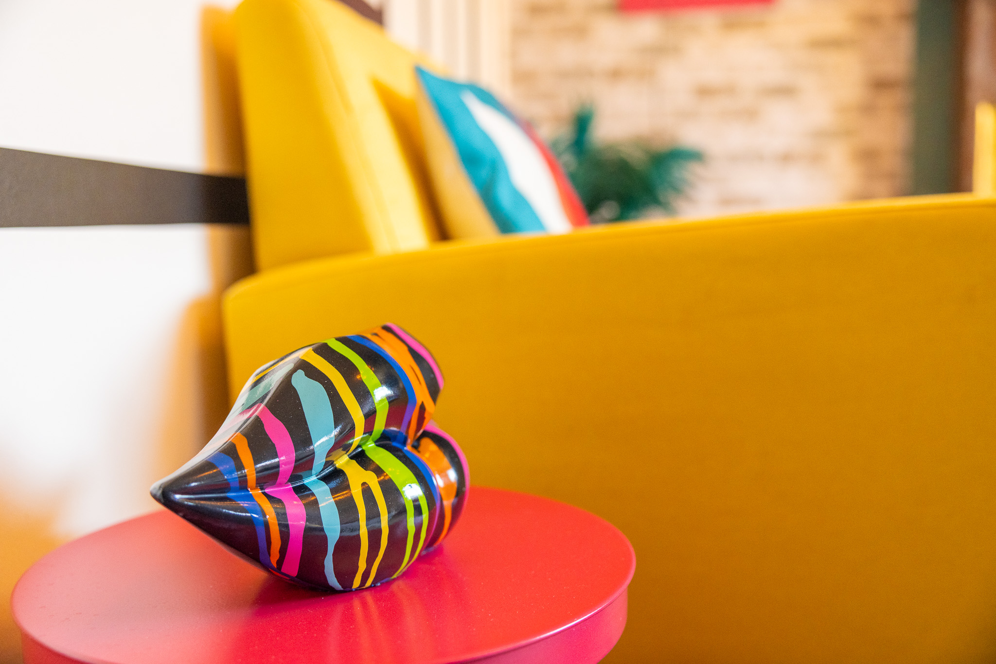 Bedside detail — orange vase and mustard cushion