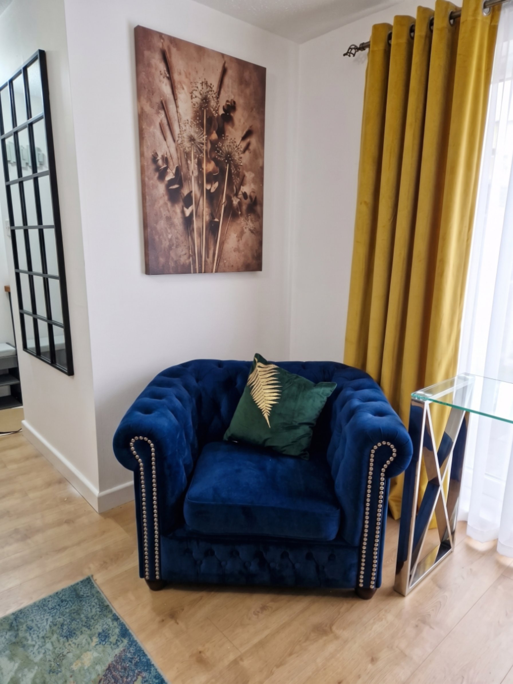 Blue Chesterfield armchair with gold fern cushion